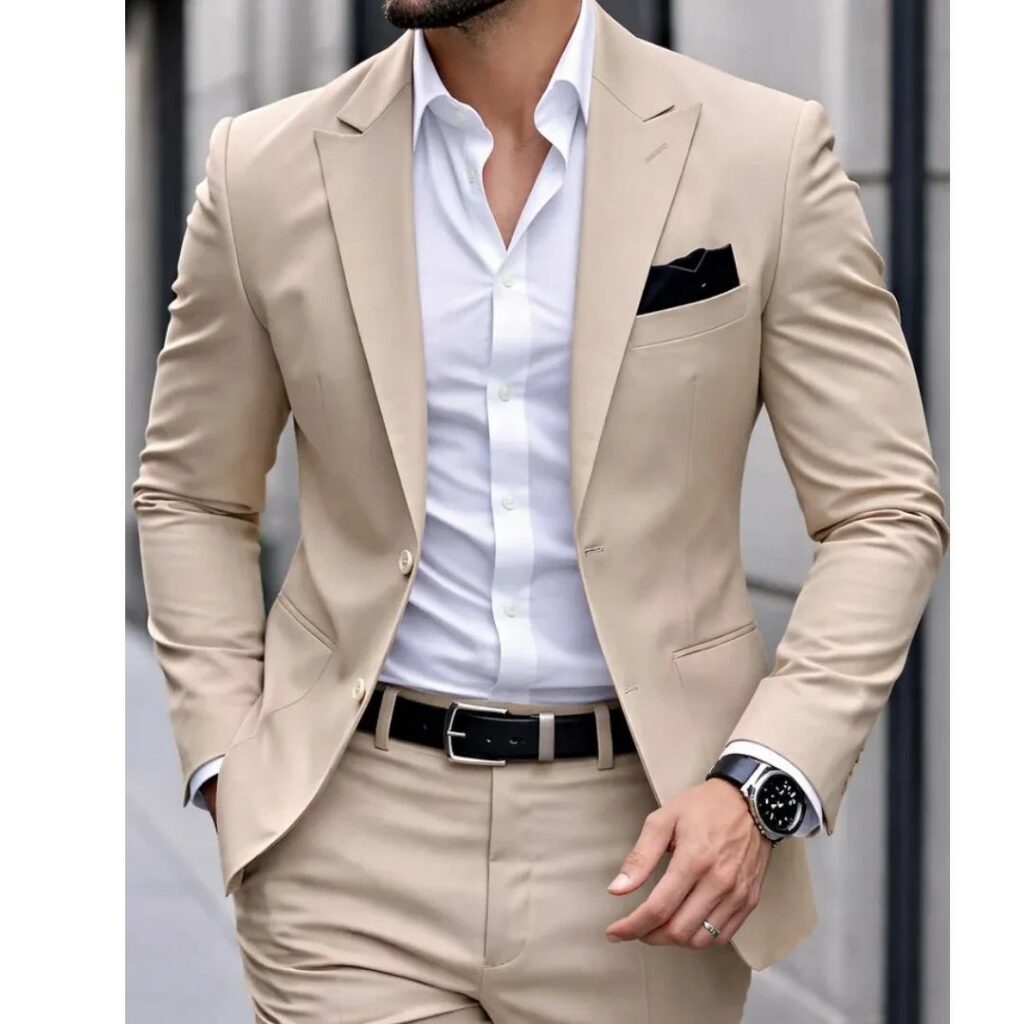 Man wearing a light beige suit with a white shirt and black accessories.