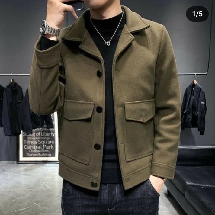 Man wearing an olive green casual jacket, black turtleneck, and dark denim jeans.