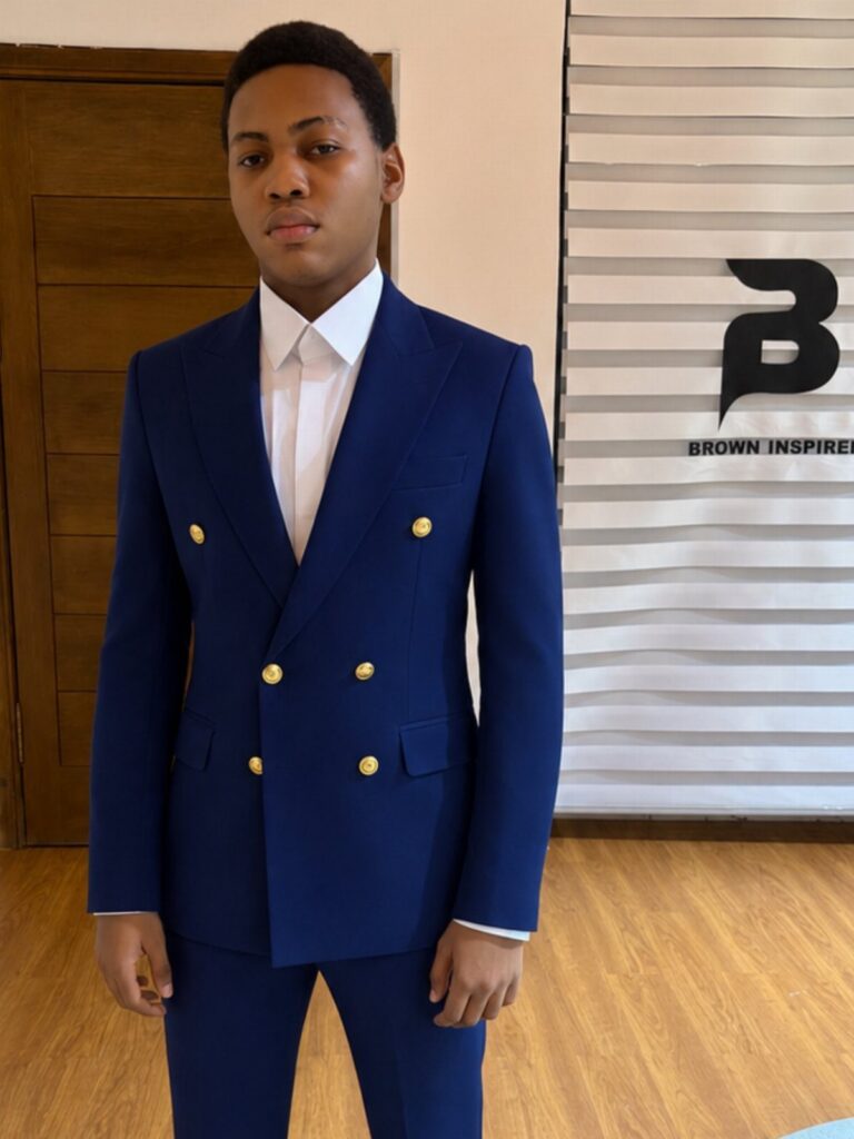 Young man posing in a vibrant blue double-breasted suit with gold buttons and white shirt.